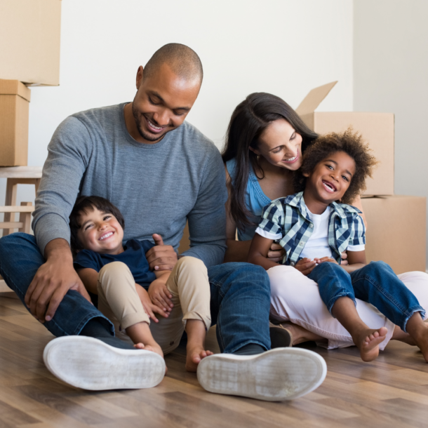 family sitting on floor of house