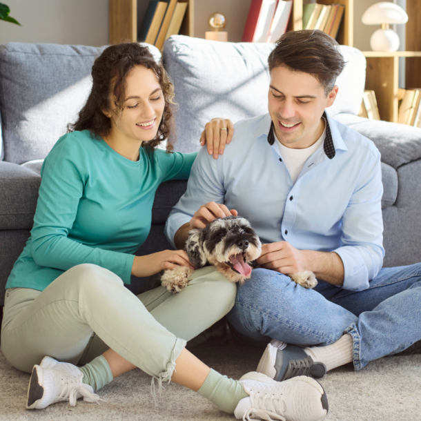 woman and man sitting on floor with dog